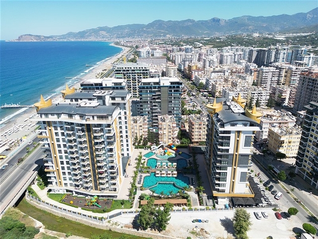 This functional one-bedroom apartment, with a total area of ​​57 sq m, is located on the second floor. The layout includes a bright living room with a kitchen area, a separate bedroom, a bathroom, and a balcony. The interior is fully furnished and equipped with appliances, air conditioning, ceramic tile flooring, a granite countertop in the kitchen, and a shower in the bathroom. This apartment is ideal for comfortable living in a vibrant coastal area. The project's infrastructure is designed for relaxation and an active lifestyle: an outdoor pool, an indoor pool, a children's pool, a water park, a sauna, a hammam, a steam room, a massage area, a fitness center, a tennis court, a volleyball court, a basketball court, table tennis, billiards, a children's play area, a green garden, a barbecue area, walking paths, a games room, internet access, television, a café, a pool bar, a conference room, a generator, outdoor parking, indoor parking, security, and a video surveillance system. Sea View Apartment with Furniture on Cebeci Towers Alanya Turkey